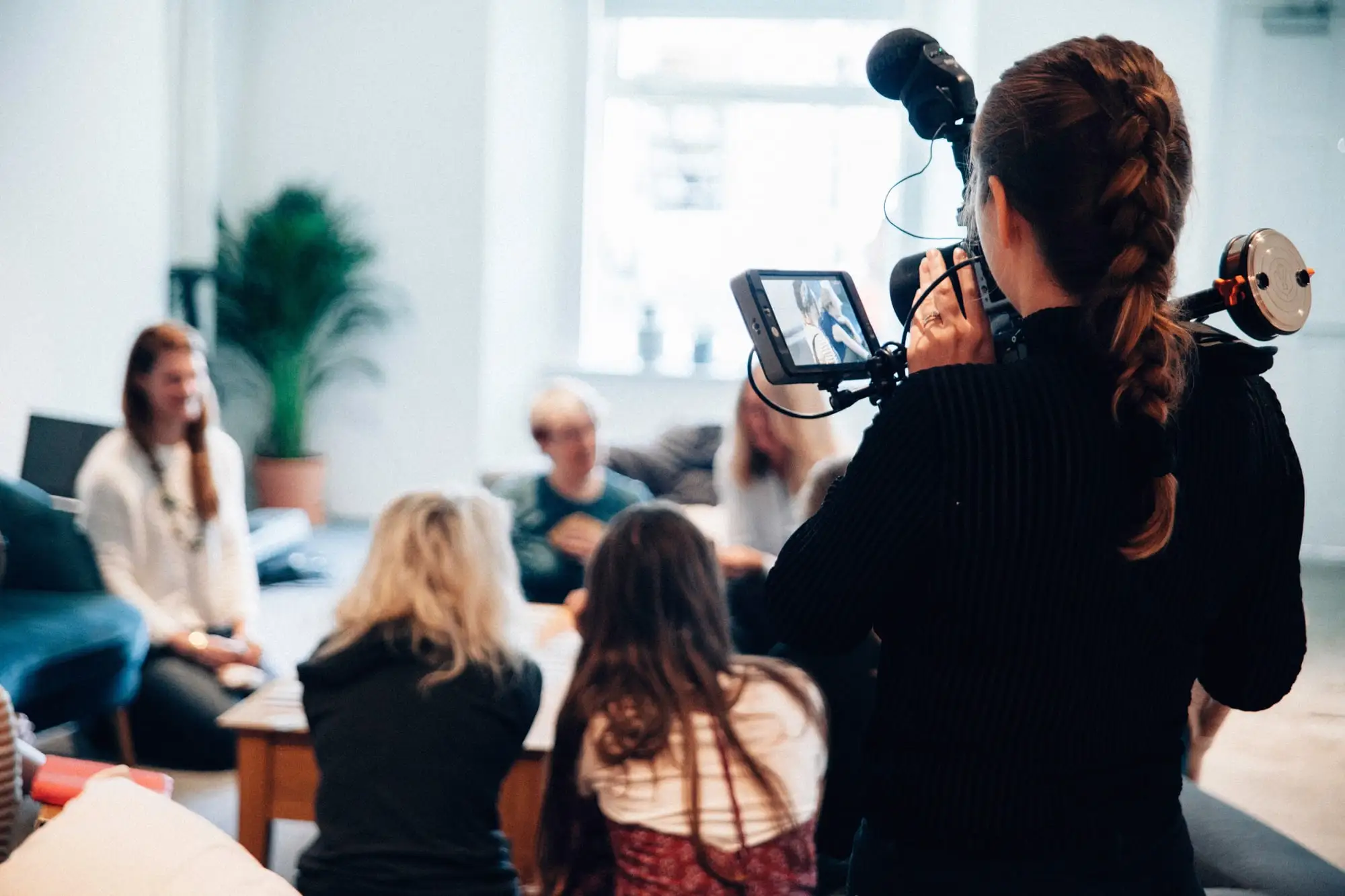 Camera operator filming a group discussion, illustrating Lee University Communication Arts storytelling